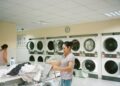 photo of woman standing inside the laundromat