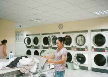 photo of woman standing inside the laundromat